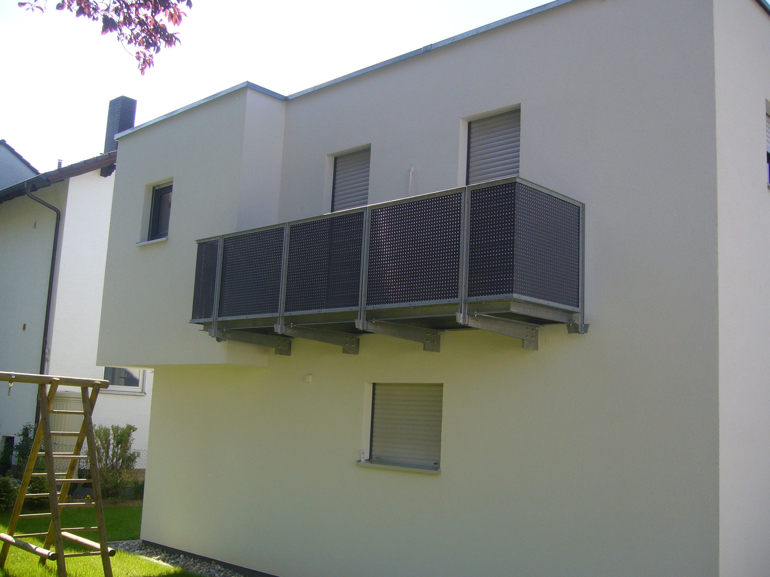 Balkon aus schwarzem Metallgitter und grauer Metallhalterung 