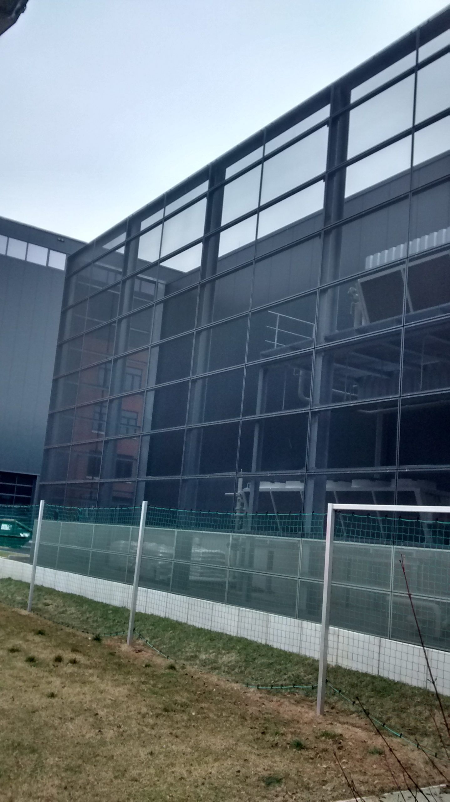 graues Metallnetz als Ballfangwand hinter einem Fußballtor