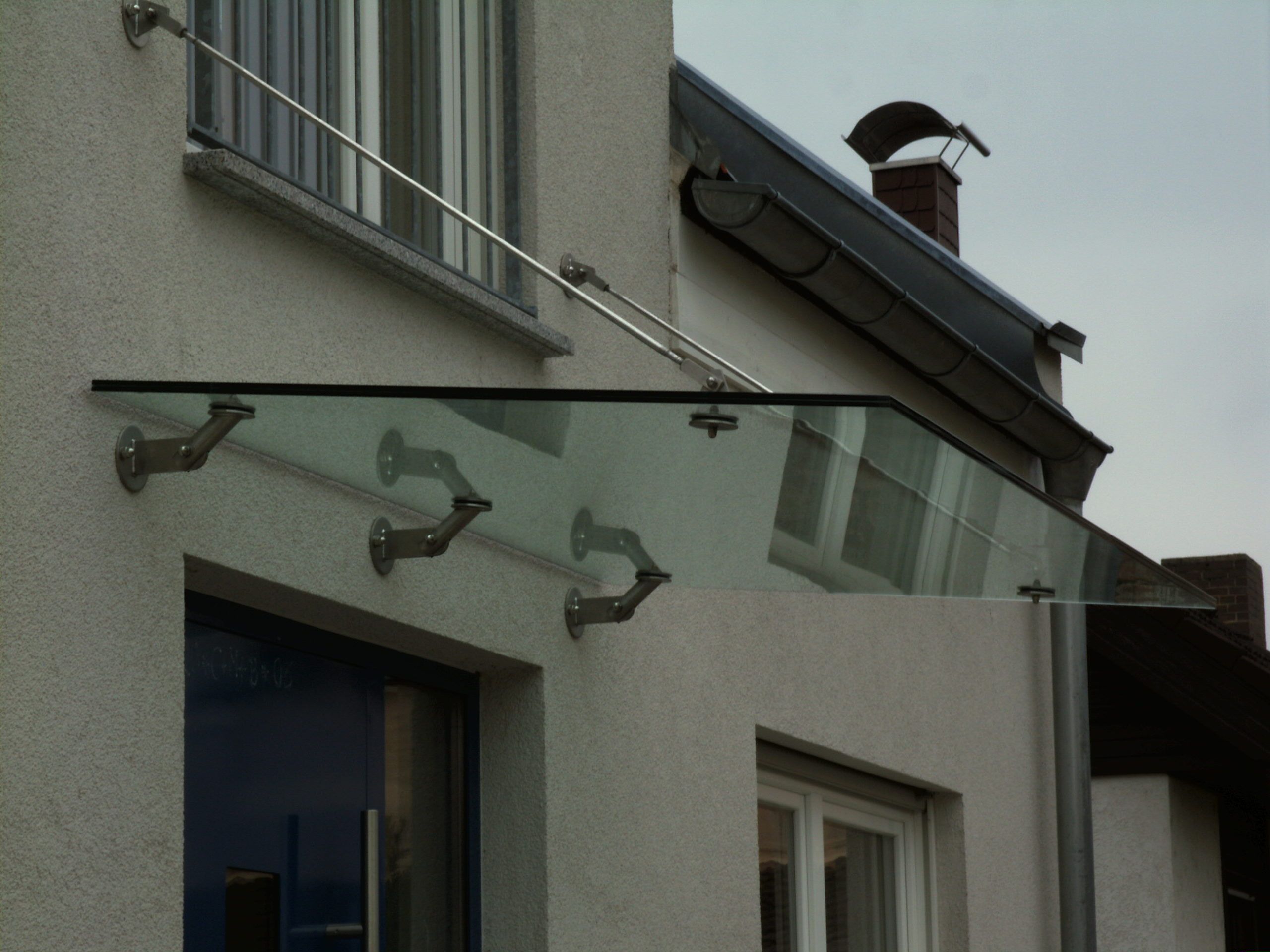 Vordach aus Glas mit Metallhalterungen 