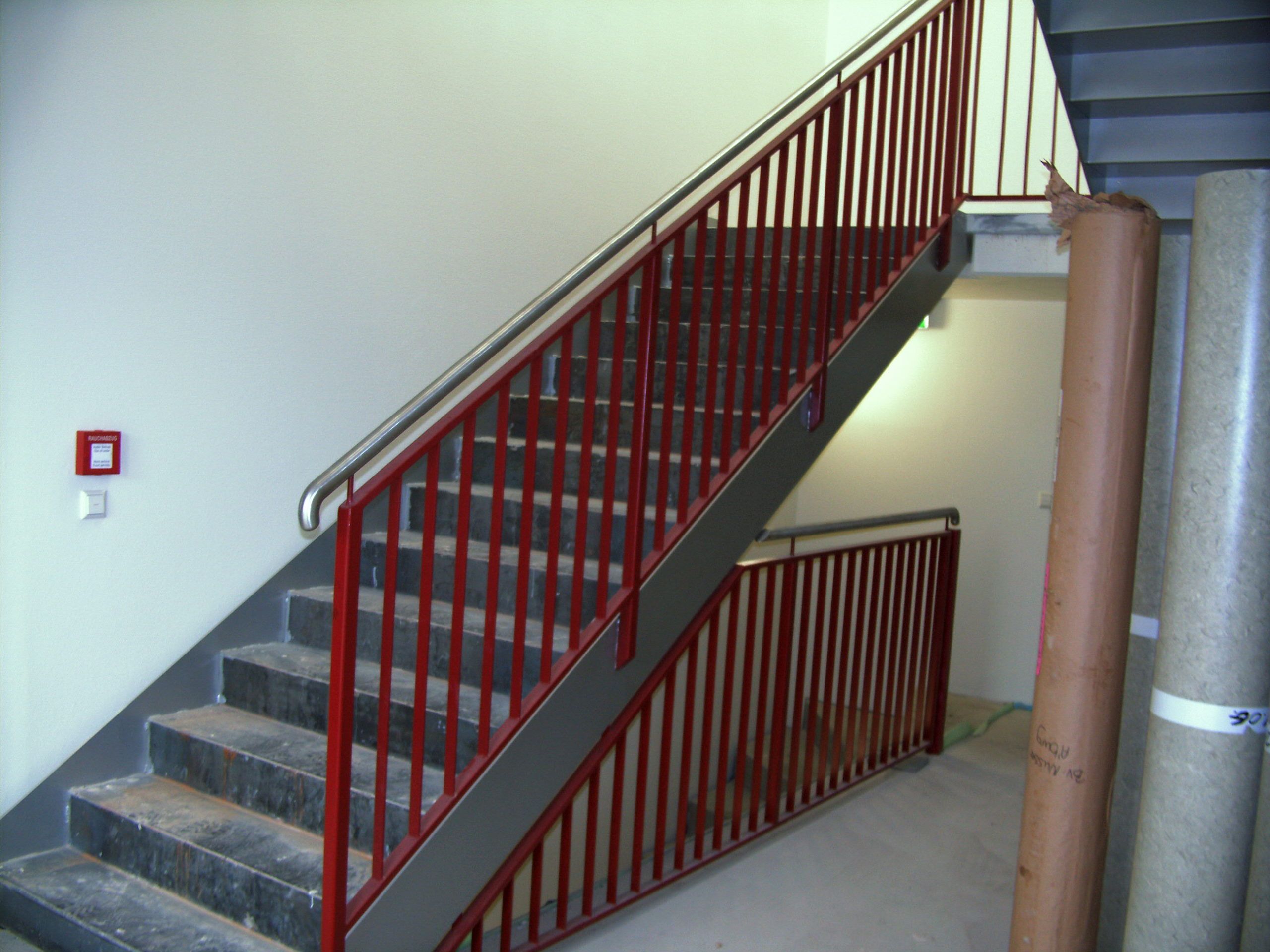 Rote Metallstreben mit grauem Handlauf 