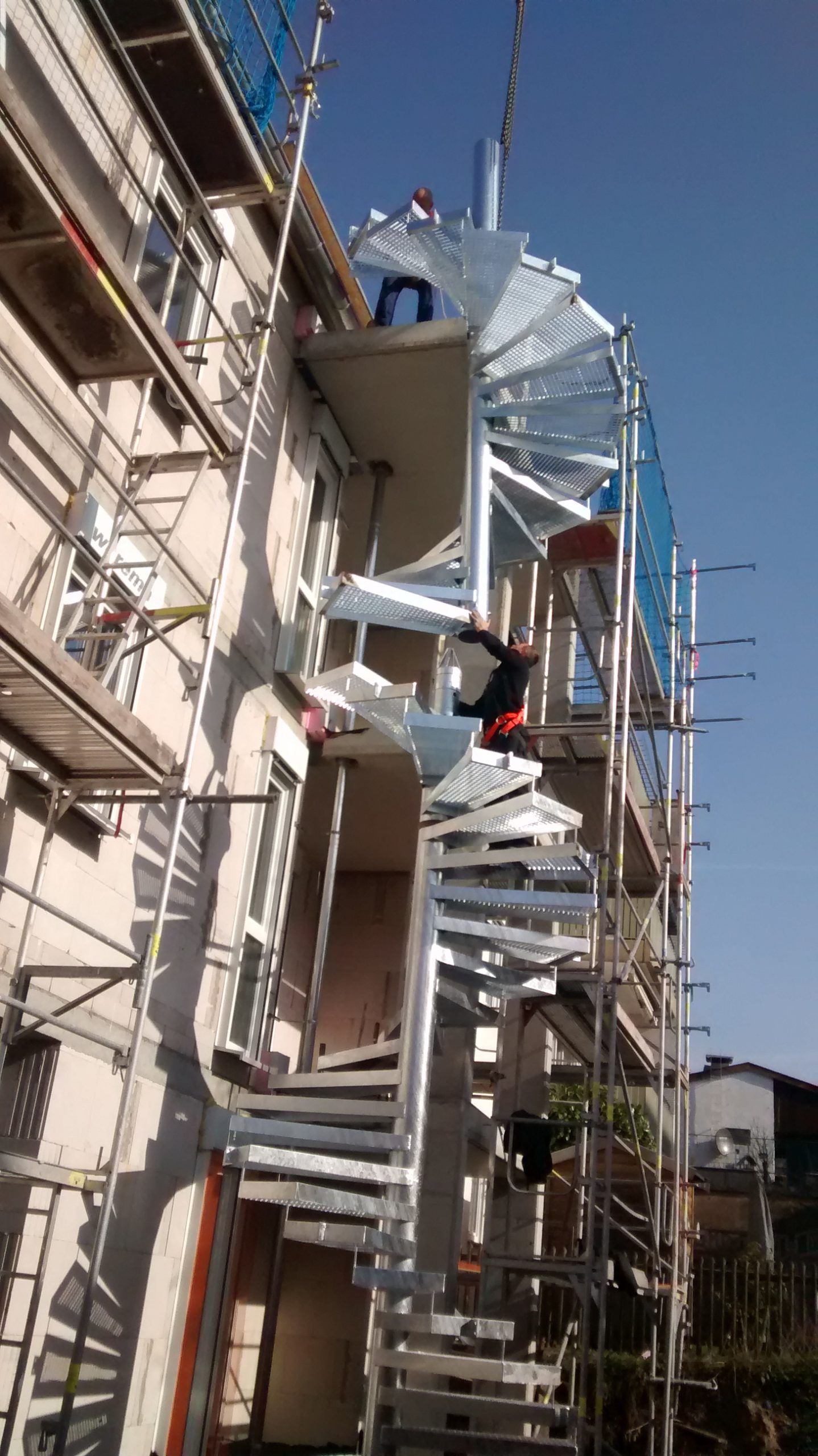 Wendeltreppe mit Stufen aus grauem Metallgitter 