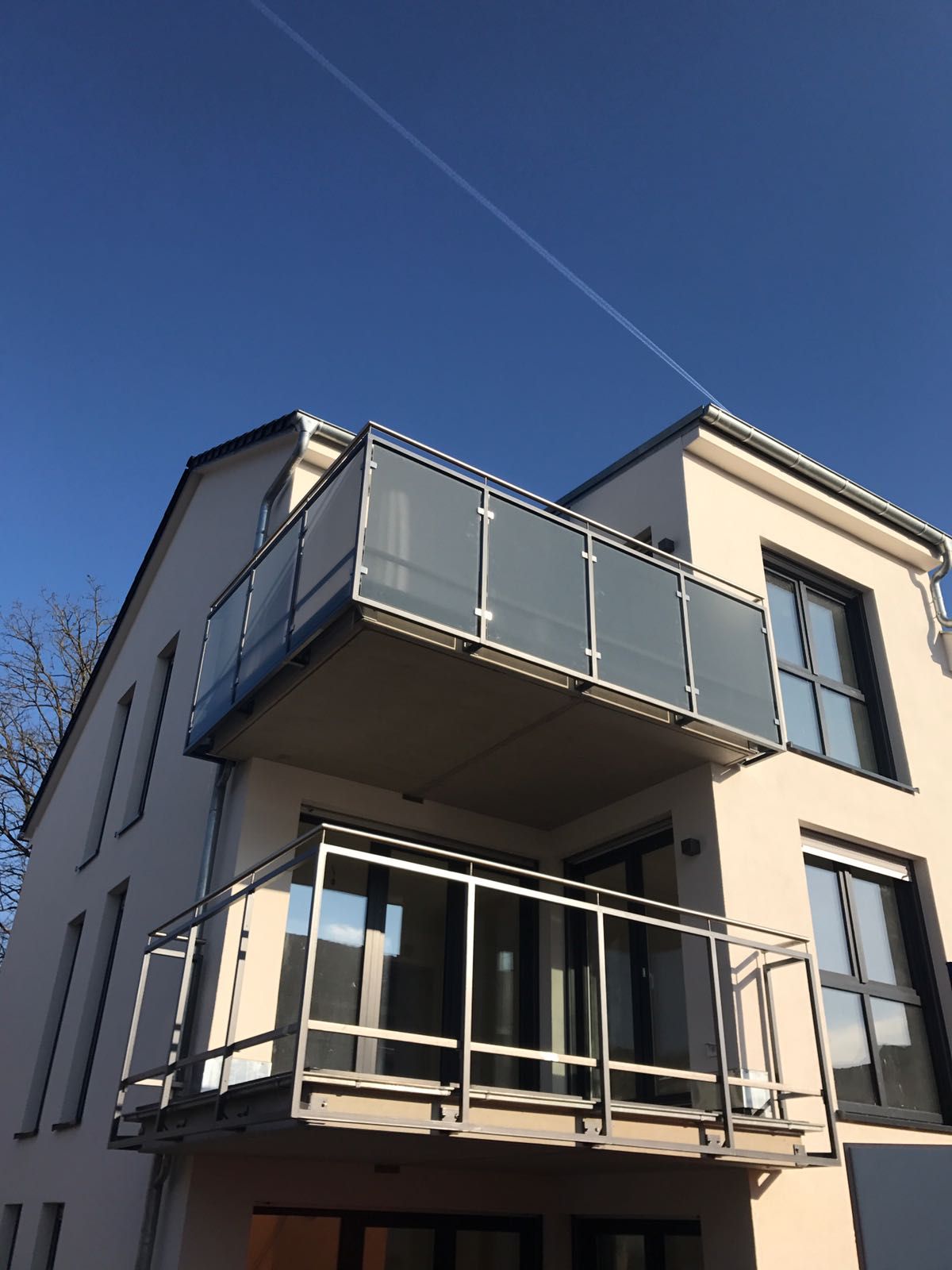 Metallrahmen teilweise um Glasplatten als Balkongeländer