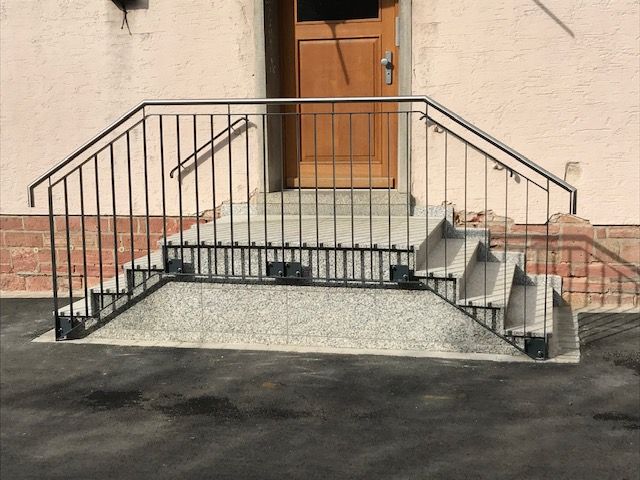 schwarze, dünne Metallstreben mit grauem Metallhandlauf 