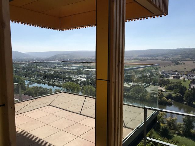 Glasgeländer mit Metallumrandung an einem Balkon