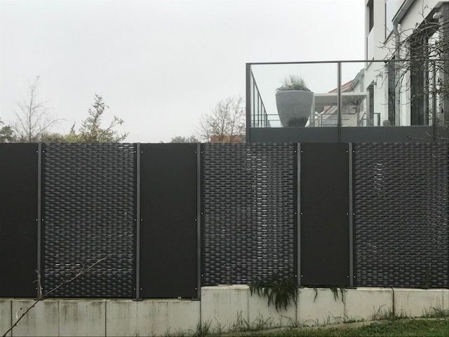 im Wechsel aus schwarzen Metallgitter und durchgehenden, schwarzen Metallplatten 