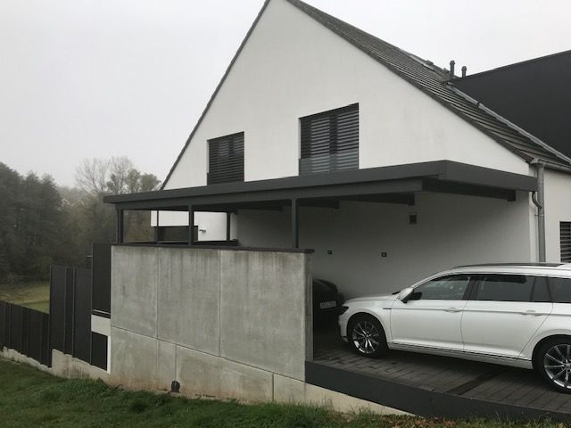 Carport mit Steinsockel und schwarzem Metalldach 