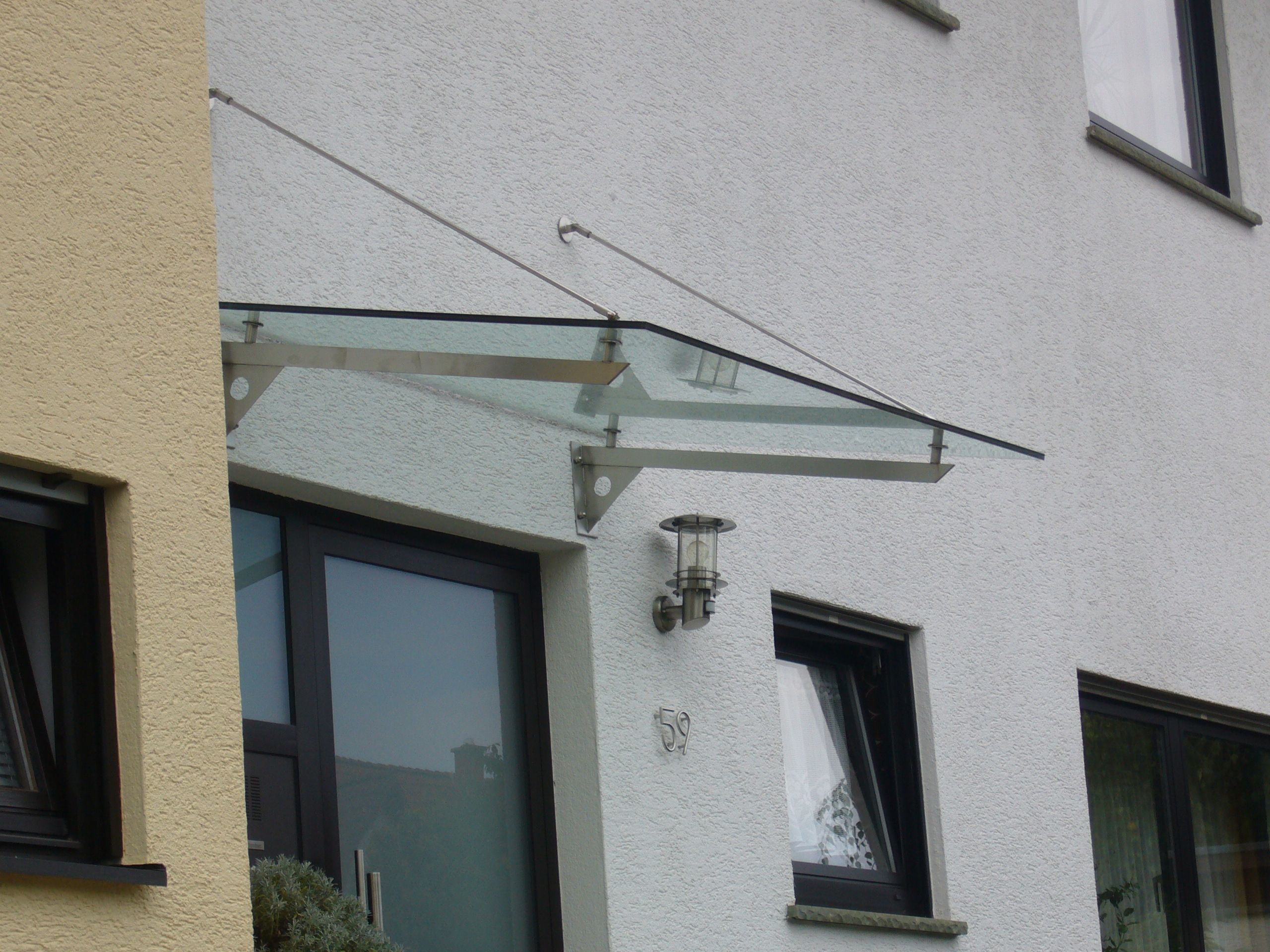 Vordach aus Glas mit Metallhalterungen 