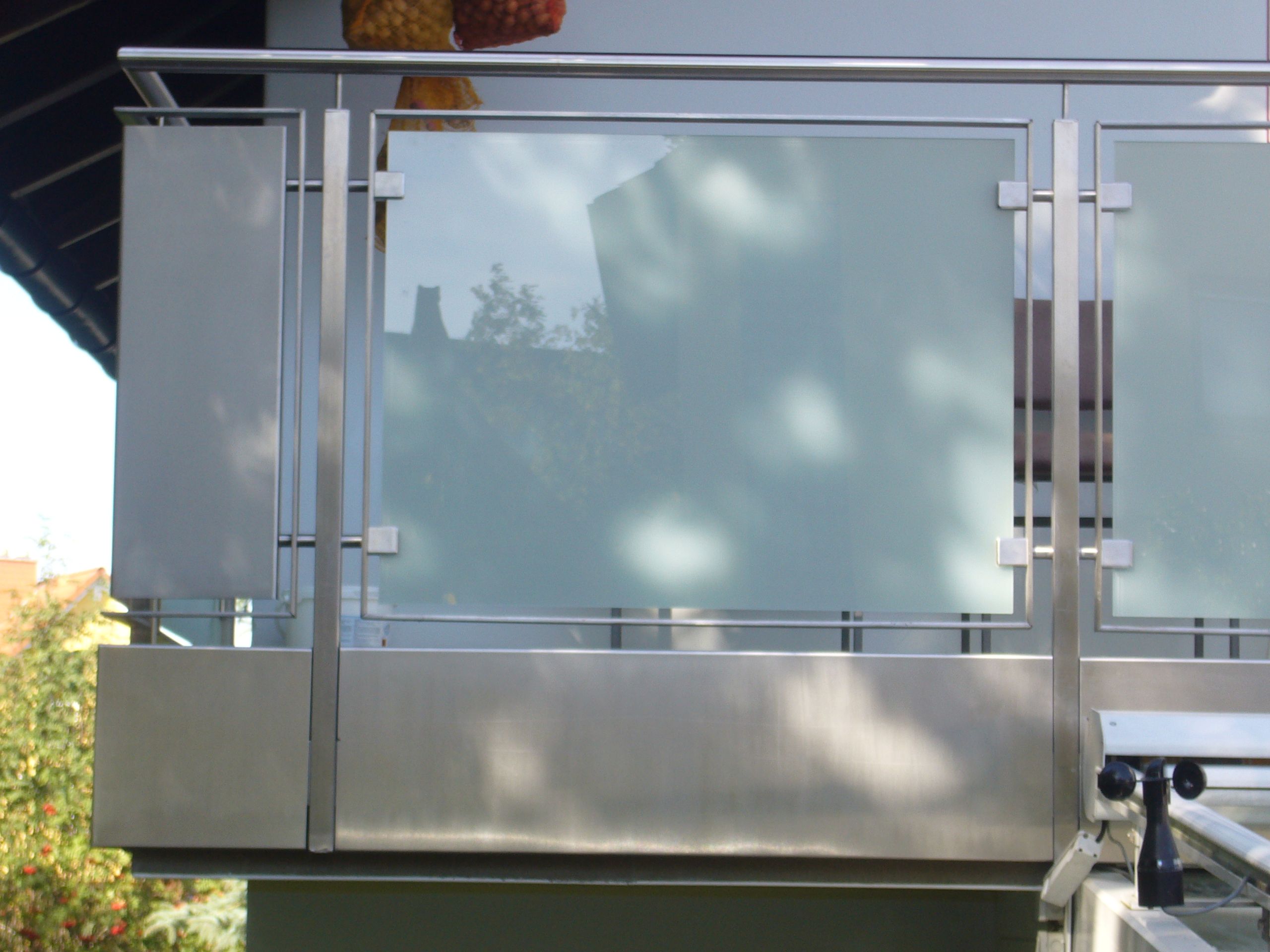 Balkongeländer aus Metallstreben und Milchglas Platten 