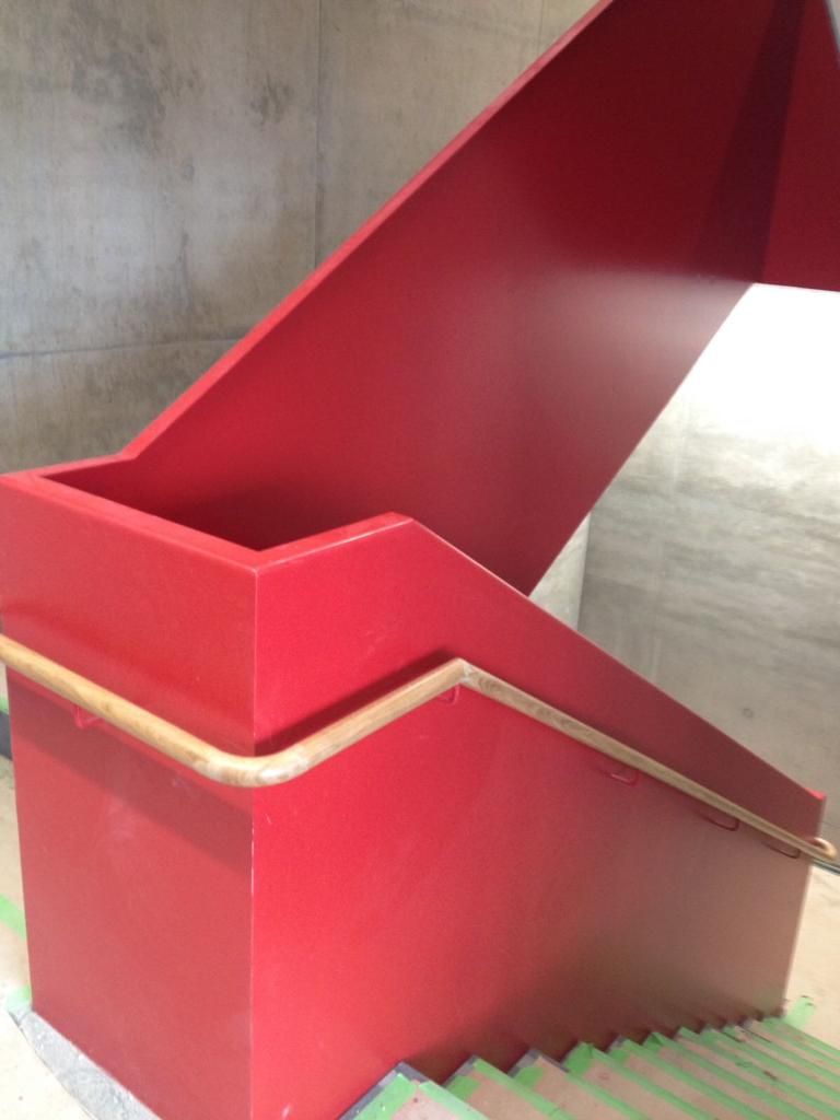 Rote Metallplatten mit Holzhandlauf