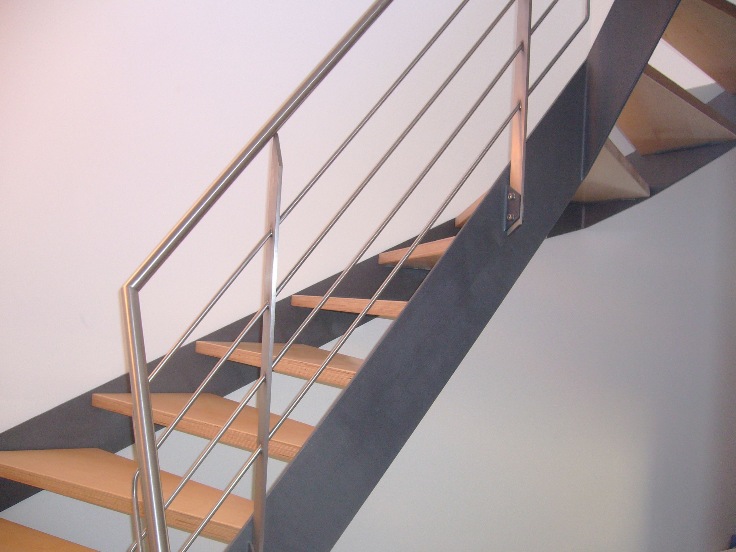 Holzstufen mit schwarzem Metallrahmen und Geländer aus grauen Metallrundstäben